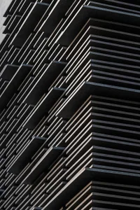 A close-up view of a modern building facade with black metallic panels.