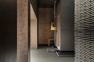 A modern corridor featuring concrete walls and lighting fixtures.