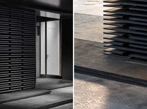 Modern minimalist entryway featuring metallic barrel vault ceiling and black metal frame.