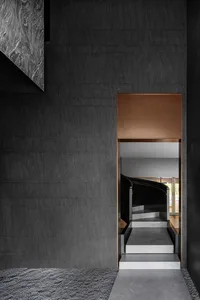A modern interior showcasing a black staircase adorned with wooden accents.