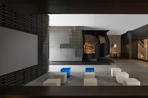 Modern lobby with concrete walls, metal staircase, and concrete floor.