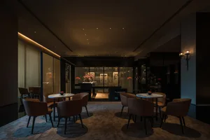 現代餐廳大廳，擺放深色皮革家具與大理石餐桌。