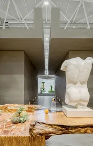 A modern exhibit hall featuring marble sculptures and tables.
