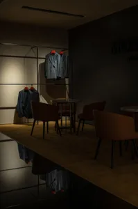 Modern retail storefront with metal structure and blue jackets hanging on a clothes rack