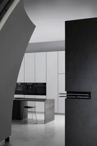 A modern, minimalist kitchen with white cabinets, concrete countertops, black appliances, and a black and metal bar stool.
