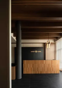 An industrial style office reception desk and counter made of wood tiles with a sign displaying 'LVXSIT YUSPA'.