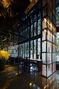 A modern restaurant interior with large glass windows and wooden furniture.
