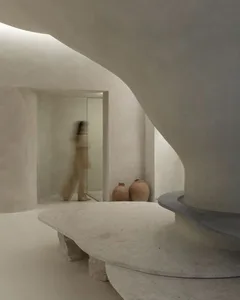 A minimalist, abstract concrete space with smooth, curved surfaces and earthy tones.