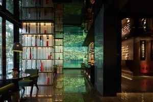 Modern minimalist hotel lobby featuring glass walls and stone flooring