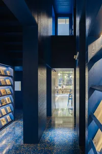 A minimalist library interior featuring blue walls and wooden elements.