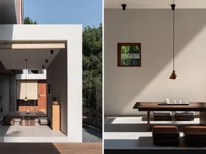 Minimalist living room with concrete walls and floor, featuring a wooden table and cushions.