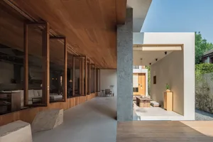 Modern minimalist residential interior featuring wooden walls, concrete flooring, and glass windows.