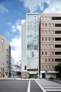 A modern building with glass walls and a clear blue sky in the background.