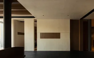 A modern living room featuring concrete walls and flooring
