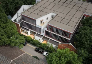 A modern office building with a glass facade and concrete walkway