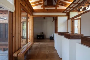 A modern residential interior with wooden walls and floors, featuring minimalist design elements and natural lighting.