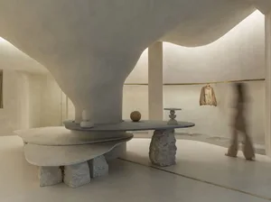 Minimalist retail space featuring a modern concrete countertop and abstract sculptures.