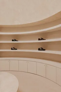 A modern room with a shoe collection displayed on shelves and cabinets made of concrete.