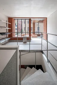 Modern staircase with brick walls, concrete steps, and aluminum handrails