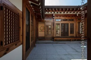 A traditional Japanese interior space with wooden walls, windows, and a stone floor.