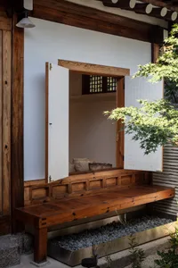 Traditional Korean architecture featuring wooden elements and open air seating area with plants.