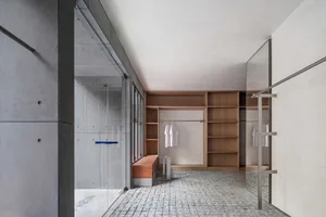 Modern minimalist closet with wooden shelves and concrete walls