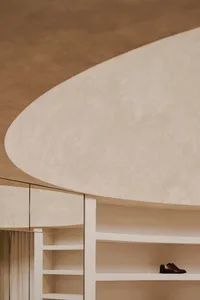 A minimalist space featuring concrete walls and a curved ceiling.