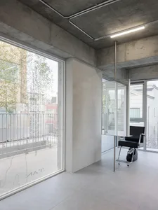 An industrial-style interior design featuring a concrete wall and large window.