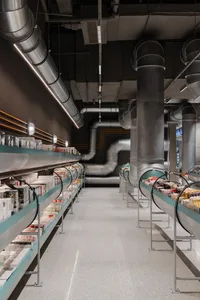 Industrial-style retail store with concrete flooring, metal shelving, and glass pipes.