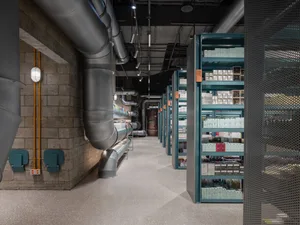 A modern retail space featuring industrial design elements such as metal pipes, concrete flooring, and glass displays.