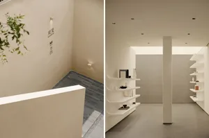 A minimalist showroom with concrete walls, white shelves, and modern design.