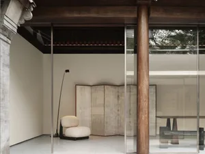 A minimalist modern interior featuring concrete, glass, and wood materials.
