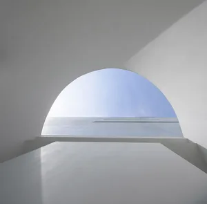 A minimalist white interior with concrete walls and floor.