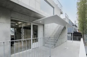 Concrete staircase and exterior building with large windows and steel railings.