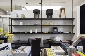 A modern interior space featuring metal shelving and curated books and objects.