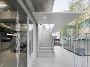 A modern interior design featuring a concrete staircase and a glass door in a studio setting.