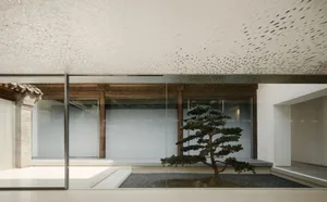 A minimalist Japanese-style interior with glass and metal frame walls showcasing modern design elements.