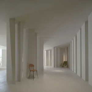 Minimalist interior design with concrete columns in a long hallway.