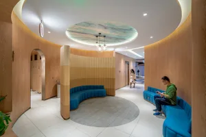 A modern office space with wooden walls featuring curved seating areas and a circular ceiling design.