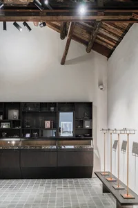 A modern retail display case with black wood shelves and glass doors, featuring sleek design elements.