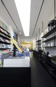 A modern retail space featuring black shelves and a bookstore with a variety of books.