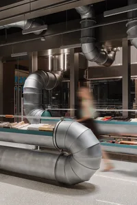 Industrial-style retail space featuring metallic ductwork and concrete flooring.