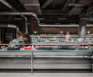 Modern storefront with steel barriers and industrial-style design.