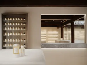 A serene spa interior featuring white marble walls and a glass counter.