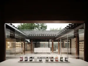 傳統茶室搭配混凝土與玻璃窗，入口前擺放一排小罐。