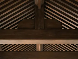 A close-up of a wooden roof structure showing intersecting beams and beams.