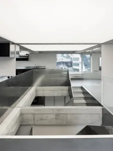 An industrial-style open space interior with concrete, glass, and metal materials.
