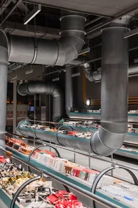 Retail storefront with exposed metal pipes and ventilation ducts