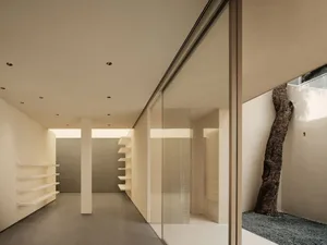 Modern minimalist interior design featuring glass walls and open space.