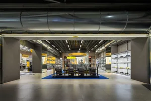 A showroom featuring industrial storefront metal and concrete elements.